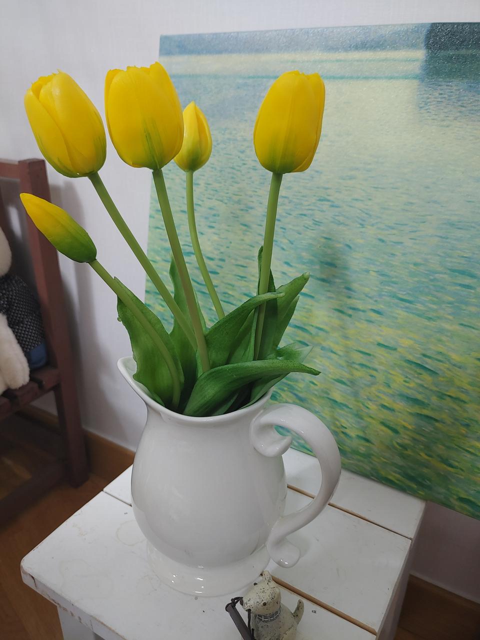 흰화기에 꽂혀있는 노란튤립조화