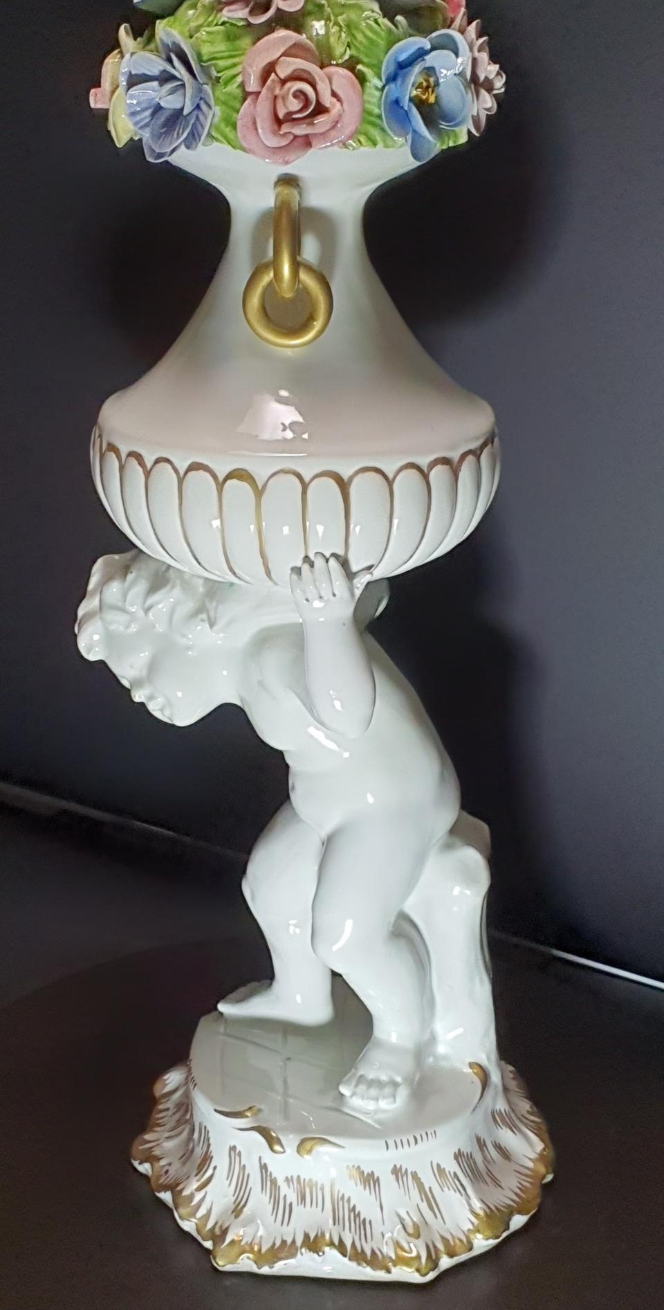 꽃화병을 무겁게 지고있는 날개없는 천사